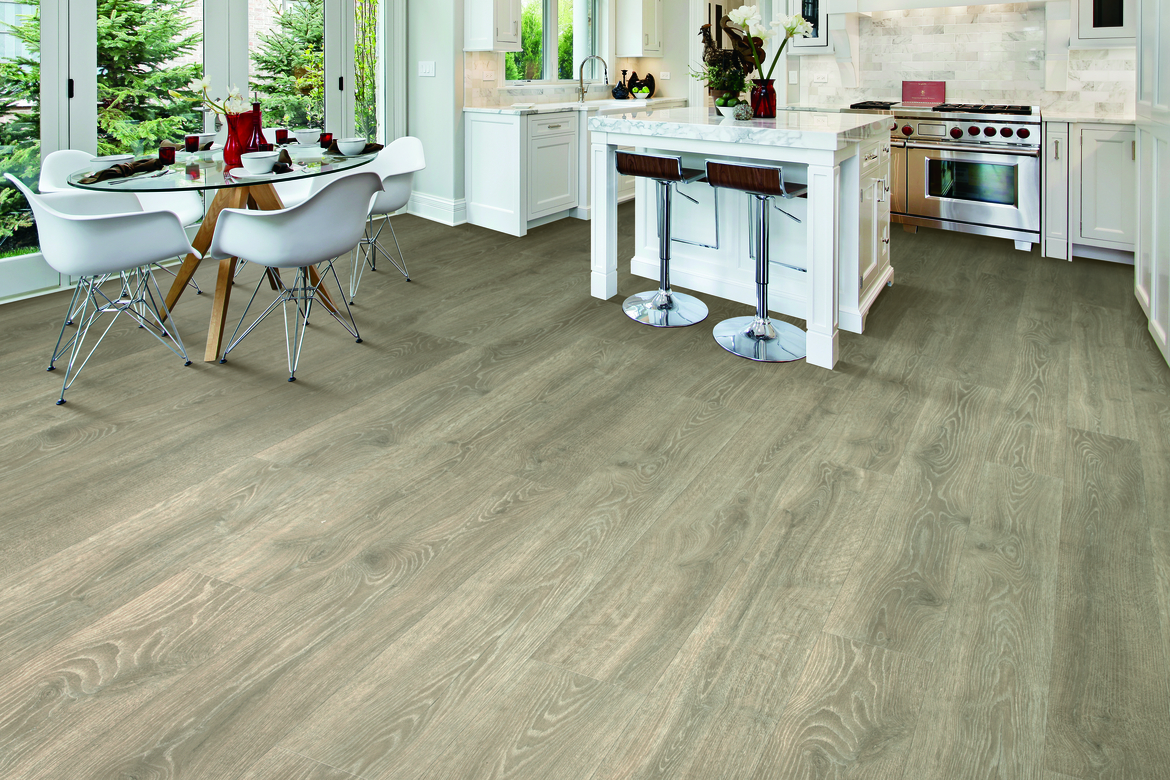 Dining area and kitchen with laminate flooring and white cabinetry